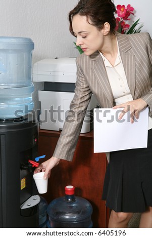 A pretty woman taking a water break in the office