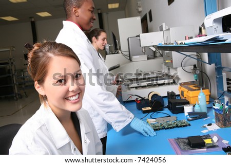 A team of computer technicians working on computer parts in the lab