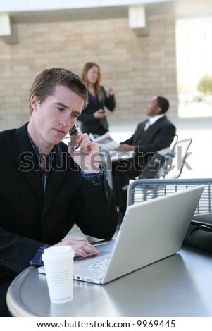 A handsome business man on laptop computer and phone