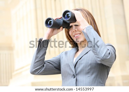 A pretty business woman looking through binoculars