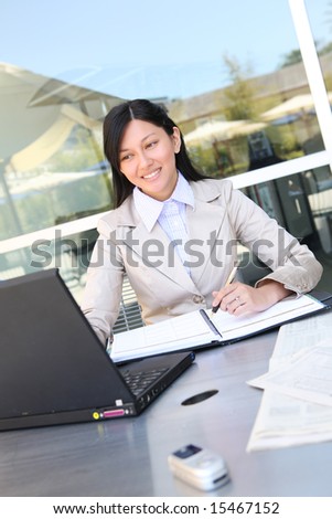 A young, beautiful asian business woman  on laptop computer