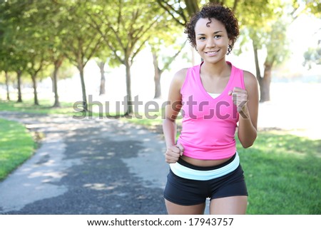 A young pretty african american woman jogging in the park