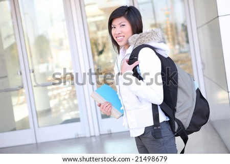 A pretty young asian woman walking on university campus