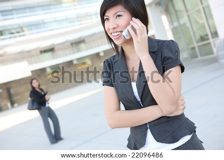 A pretty asian business woman walking to the office on phone
