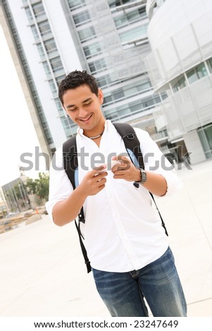 A handsome young student texting at college university