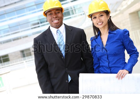 A pretty asian woman and african man working as architects on a construction site
