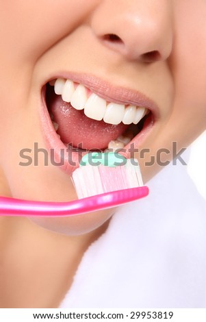 A close-up of a beautiful woman brushing her teeth