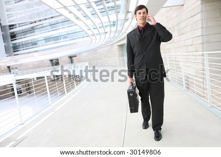 A young, handsome business man on phone at place of work