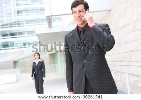 A young, handsome business man at place of work on phone