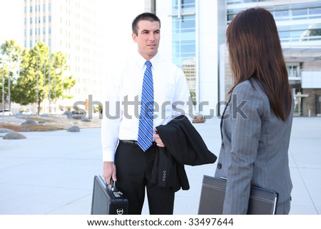 An attractive man and woman business team outside office building