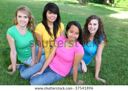 Smiling Happy pretty girl friends in the park with colorful shirts