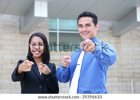 An attractive, diverse business team at the office building pointing