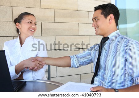 Attractive man and woman business team shaking hands