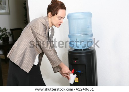 A pretty woman taking a water break in the office