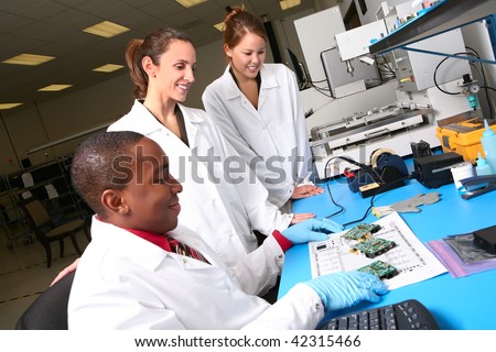 A team of computer technicians working on computer parts in the lab