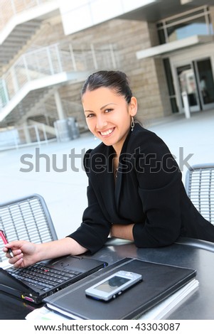 A young pretty business woman at office building on laptop computer