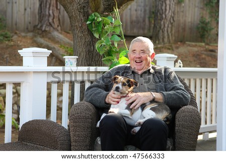 An upbeat joyful retired elderly man at home relaxing with dog