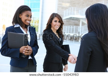A pretty diverse young business woman team at office building handshake
