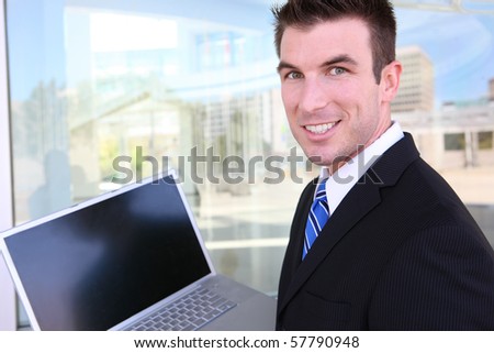 A handsome business man at office building using laptop computer