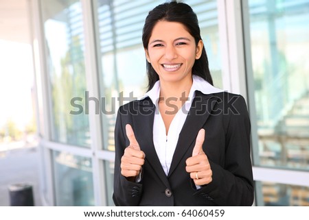 A pretty Indian business woman with thumbs up celebrating success