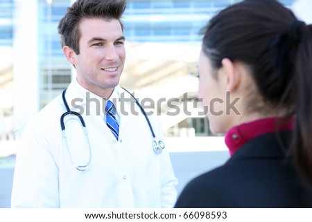 A handsome man doctor talking with his woman patient outside hospital