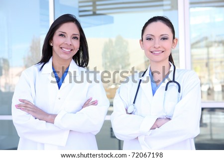 Two pretty young women nurses outside hospital smiling