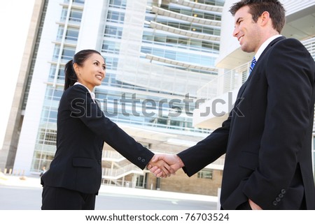 A pretty asian woman handshake with handsome man at office building