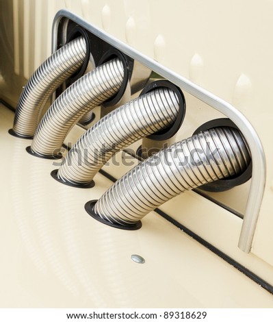 Close up of a group of shiny exhaust pipes on a vintage car