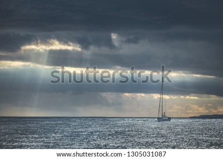 Similar – Image, Stock Photo Lonely yacht in gray water with dark mountains under cloudy sky