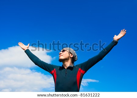 young active man standing on the background of blue sky