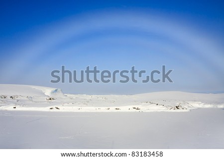 rainbow over snow-covered slopes of the Antarctica