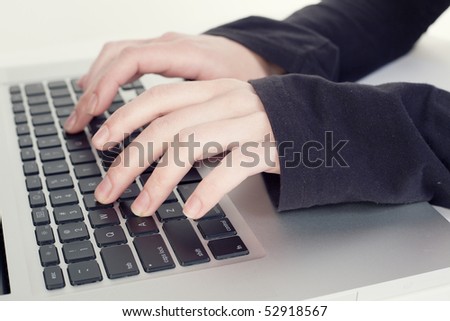 Human hands typing on a laptop