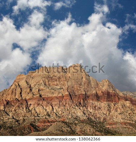 Mountain in Southwestern Nevada with red sedimentary layers of iron oxide.
