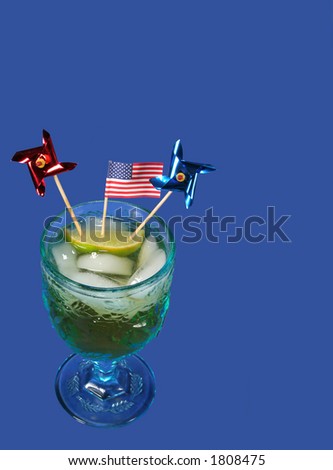 A cocktail sporting an American flag and twirlers with space for text, vertical, on blue