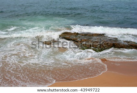 Ocean surf breaks on a rocky shore in Maui, Hawaii.