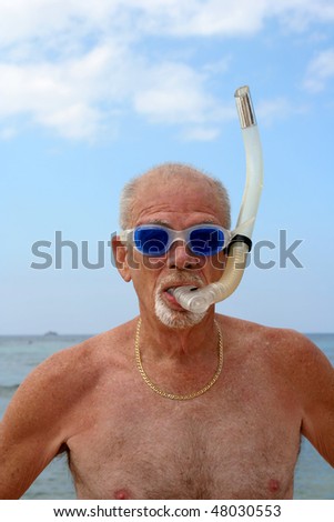 Man on a beach wearing blue dive goggles and snorkel