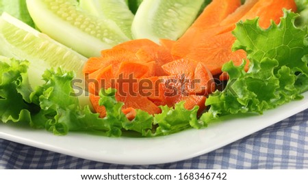 Salad of cucumbers, carrots and lettuce on plate