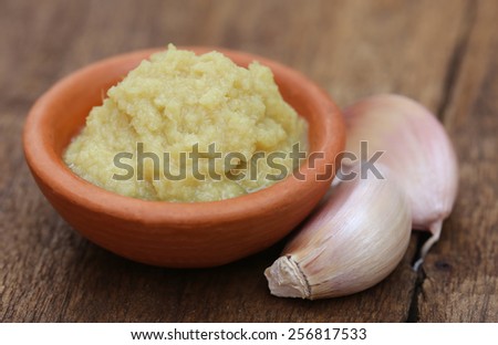 Fresh crushed ginger with garlic on wooden surface