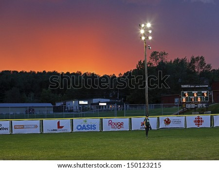 SHERBROOKE, CANADA - August 4: The sun sets on a women\'s softball game at the Canada Games August 4, 2013 in Sherbrooke, Canada.