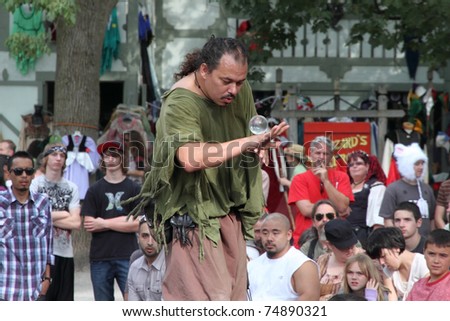 KENOSHA, WI - SEPTEMBER 4: A jongleur plays with a crystal ball by rolling it around his body at the annual Bristol Renaissance Faire on September 4, 2010 in Kenosha, WI