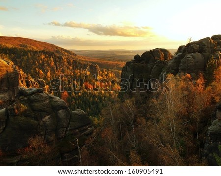 Autumn evening panorama view over sandstone rocks to fall valley of Saxony Switzerland. Sandstone peaks and hills increased from colorful background.