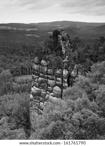 Autumn evening view over sandstone peak to valley of Saxony Switzerland. Sandstone peaks and hills increased from background. Black and white photo.