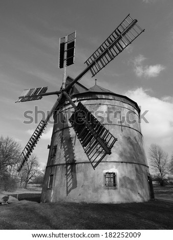 Renewal wind mill house into summer house. New red roof, repaired wind blades. Black and white photo.