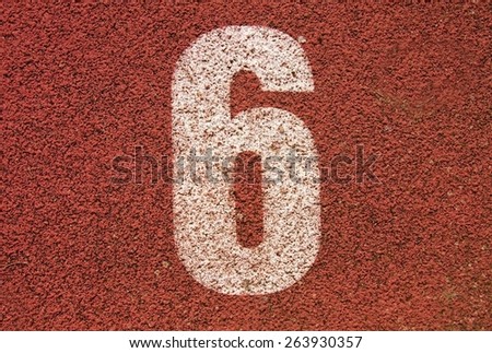 White track number on red rubber racetrack, texture of running racetracks in small stadium