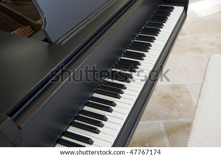 Close up view of black Grand Piano and chair