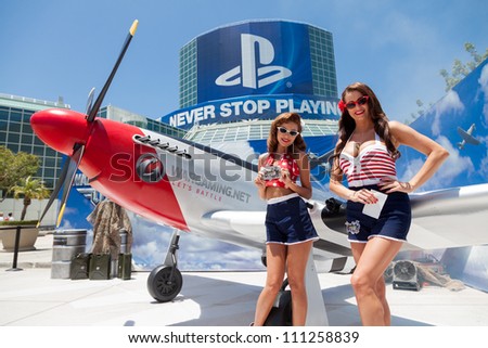 LOS ANGELES - JUNE 8: Pin ups posing for media at the entrance of the show with PlayStation sponsorship in the background during E3 2012, world video games Expo June 8, 2012 in Los Angeles, CA