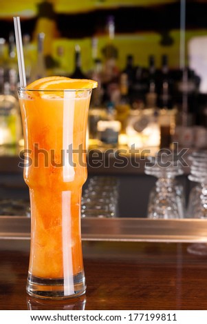 Orange drink with bar background
