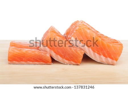 Three pieces of salmon on cutting board