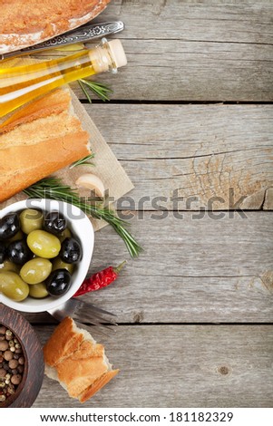 Italian food appetizer of olives, bread, olive oil and balsamic vinegar on wooden table background