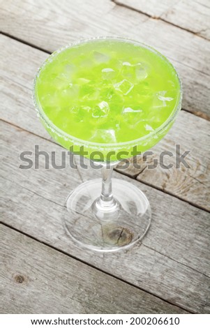 Classic margarita cocktail with salty rim on wooden table